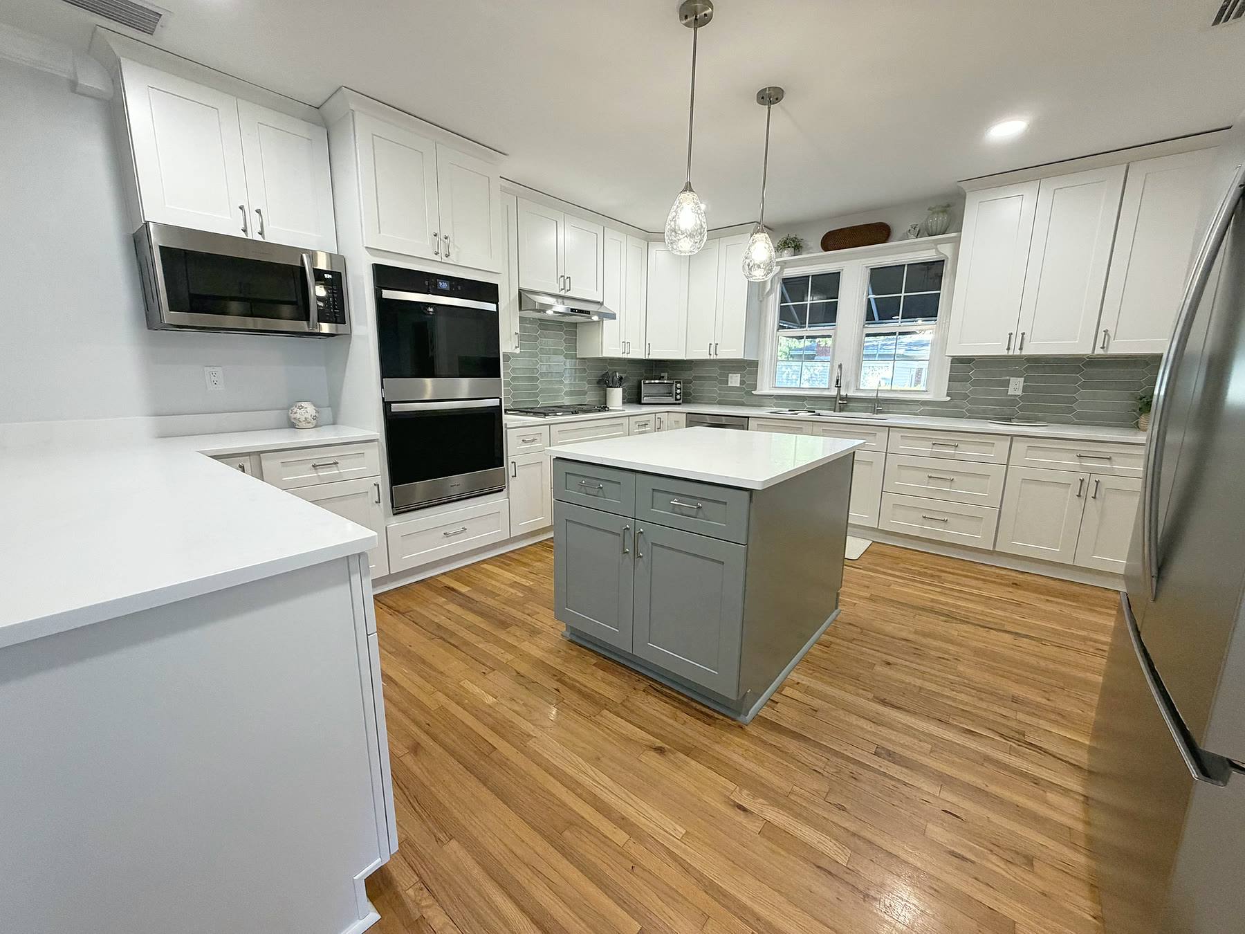 Quartz kitchen island and stainless double wall ovens in a South Tampa kitchen remodel by 618 Construction