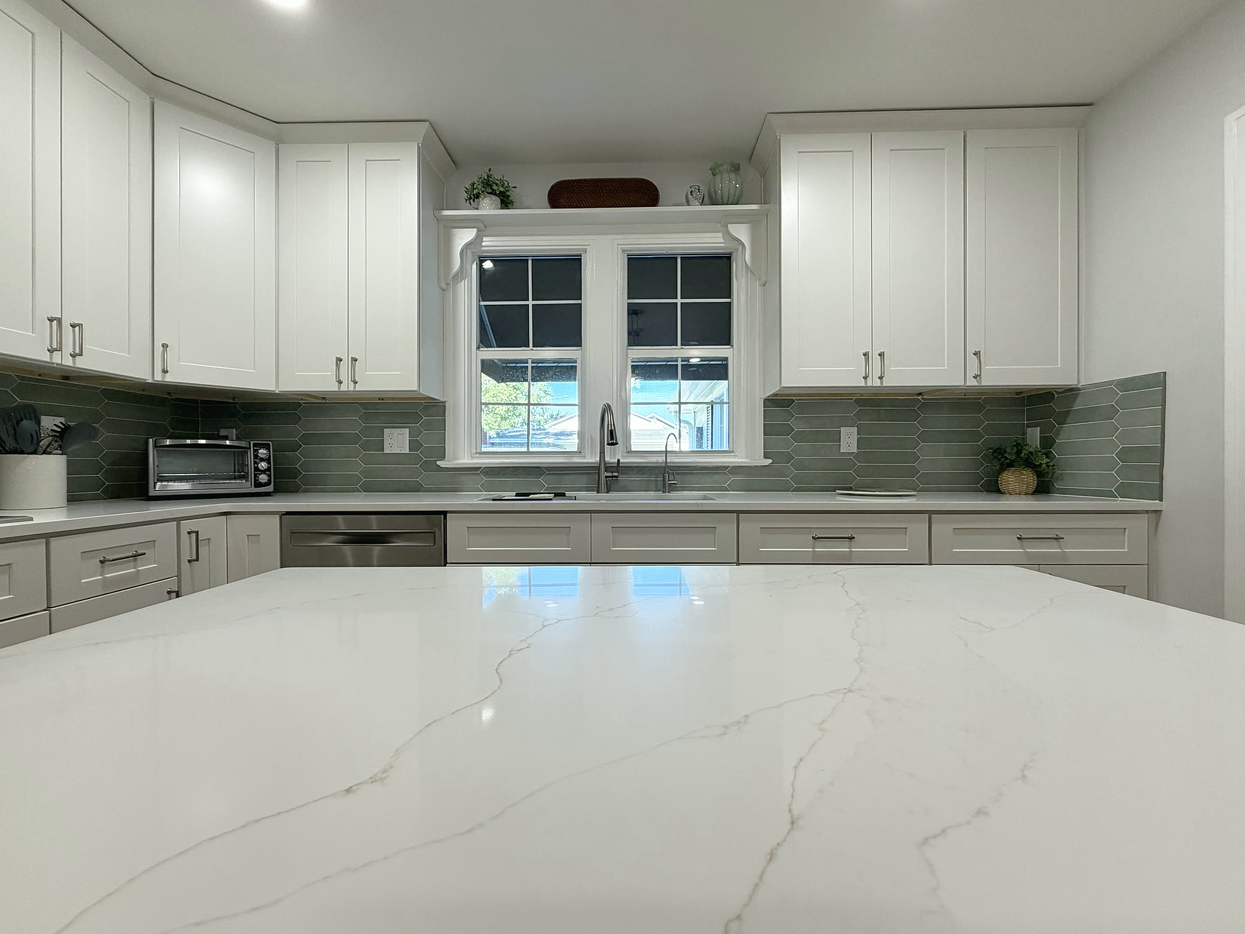 Quartz countertops and undermount sink beneath a window in a South Tampa kitchen remodel by 618 Construction