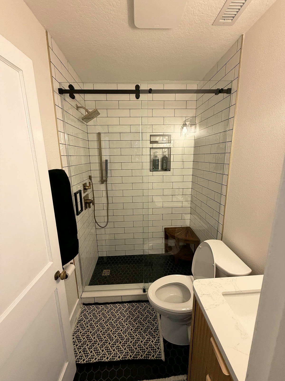 Finished St. Petersburg bathroom remodel with subway tile and a glass walk-in shower by 618 Construction