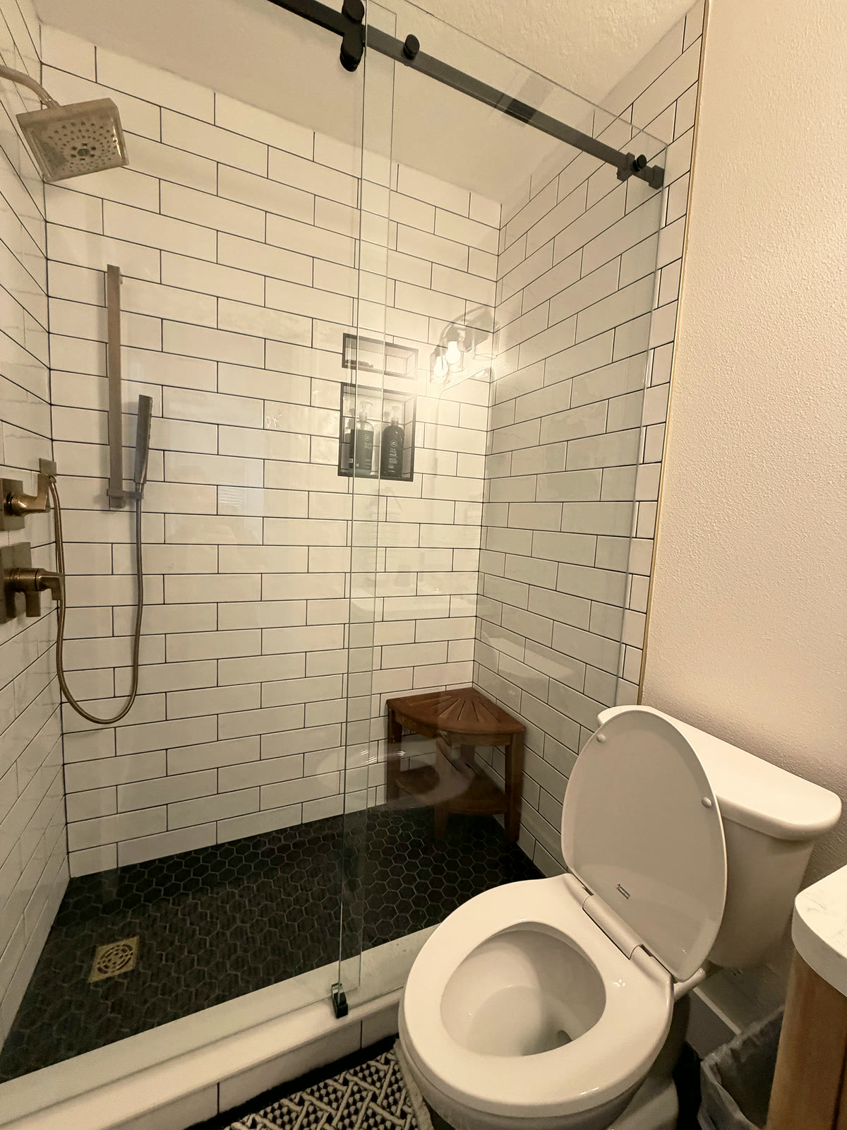 Subway tile shower with tiled niche and rain head in a St. Petersburg bathroom remodel by 618 Construction